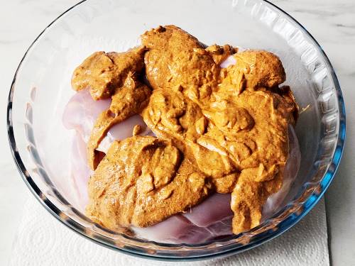 mixing chicken with tandoori marinade