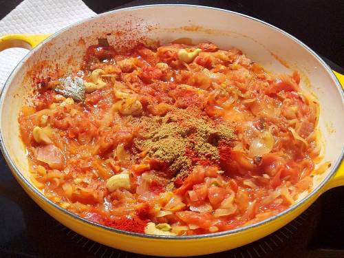 adding spices to make malai gravy