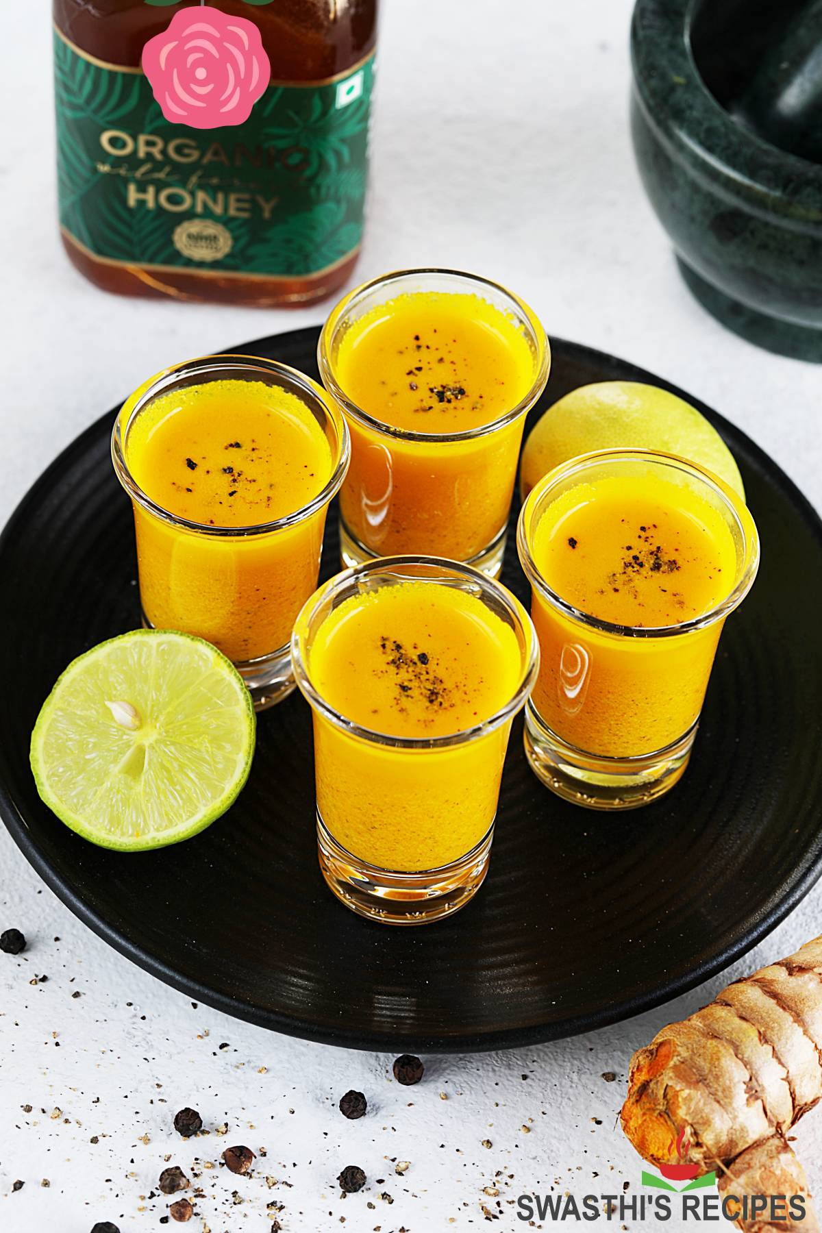 Turmeric Shots served in shot glasses, garnished with black pepper
