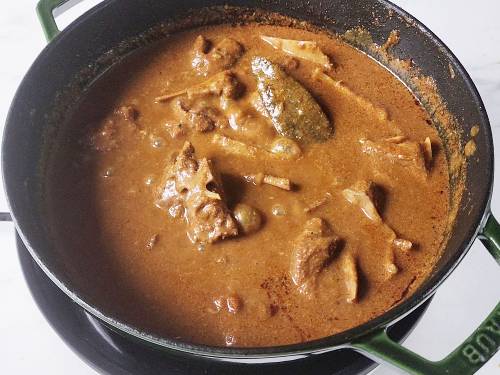 simmering goat curry in a ditch oven