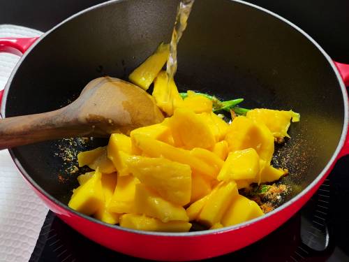 adding mangoes to the pan